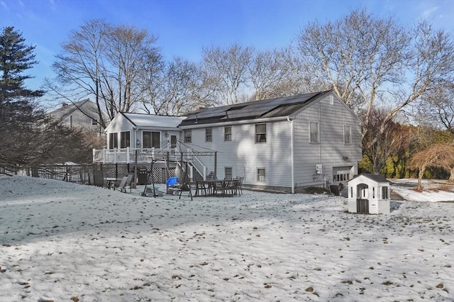 snow covered house featuring a wooden deck