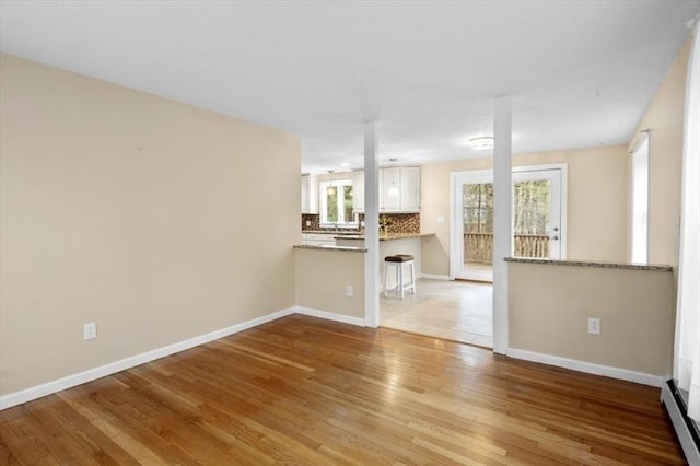 unfurnished living room featuring baseboards and wood finished floors