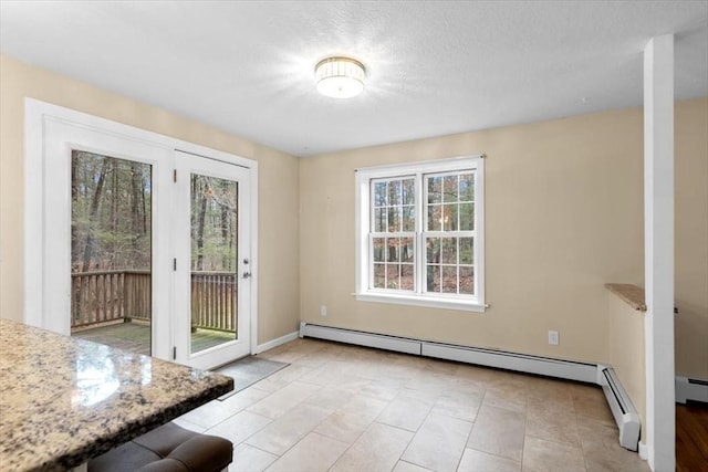 doorway to outside with a baseboard heating unit, baseboards, and a textured ceiling