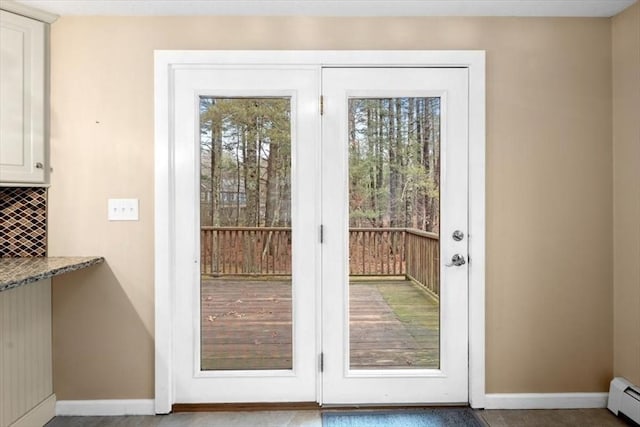 entryway featuring plenty of natural light, a baseboard heating unit, and baseboards