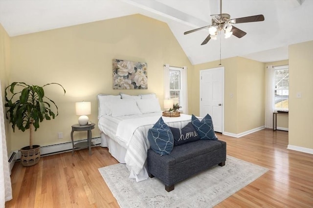 bedroom featuring a baseboard heating unit, lofted ceiling, baseboards, and light wood finished floors