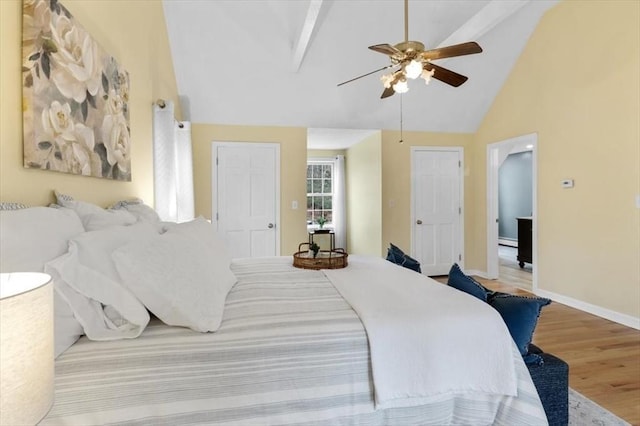 bedroom with baseboards, ceiling fan, beam ceiling, wood finished floors, and high vaulted ceiling