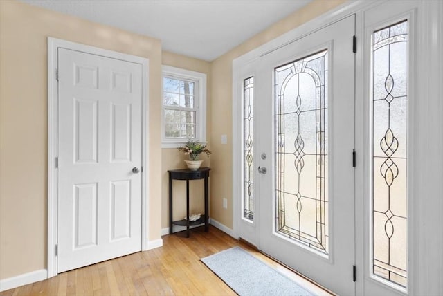 foyer with light wood-style flooring and baseboards