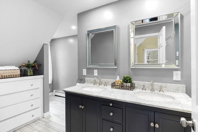 full bath featuring double vanity, a baseboard radiator, and a sink