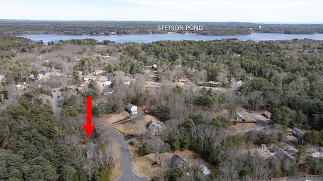 birds eye view of property featuring a forest view and a water view