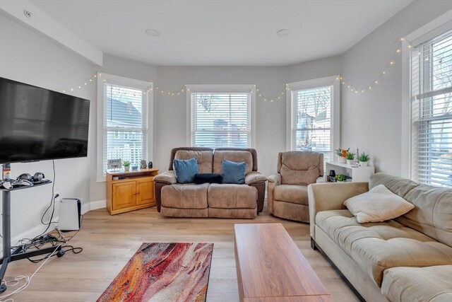 living area featuring baseboards and light wood-style flooring