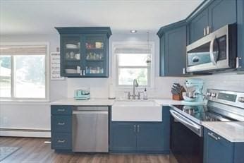 32 Nancy Rd, Milford, MA 01757 - kitchen with appliances with stainless steel finishes, blue cabinets, a baseboard radiator, and light countertops