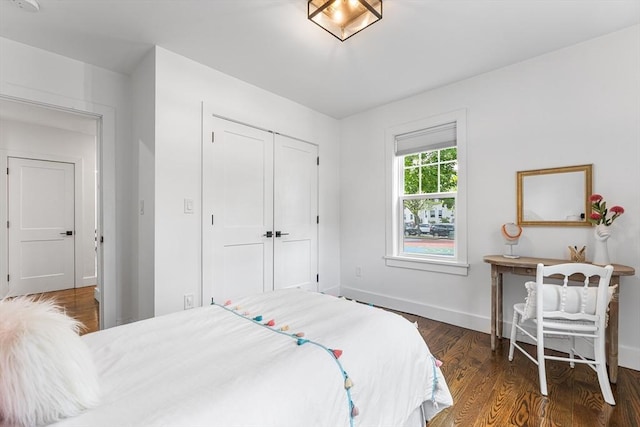 bedroom featuring baseboards, wood finished floors, and a closet