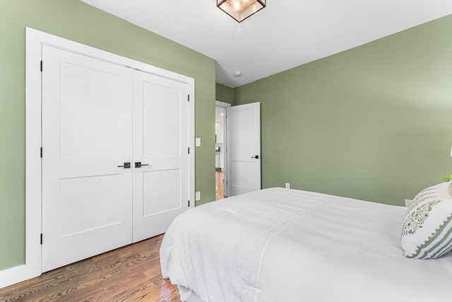 bedroom with wood finished floors and a closet