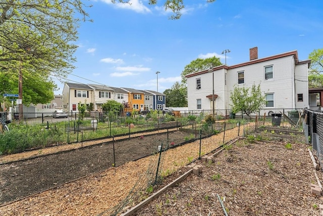 view of yard featuring a residential view, a vegetable garden, and fence
