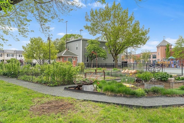 view of home's community with a garden and fence