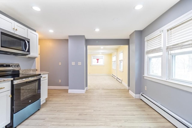 kitchen with white cabinets, stainless steel appliances, and a baseboard heating unit