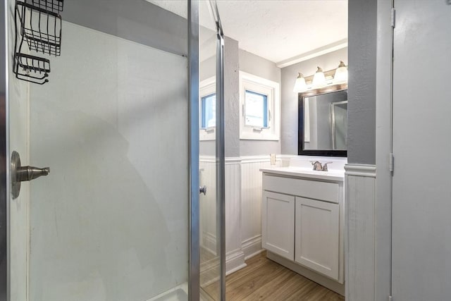 bathroom with a shower with door, vanity, and hardwood / wood-style floors