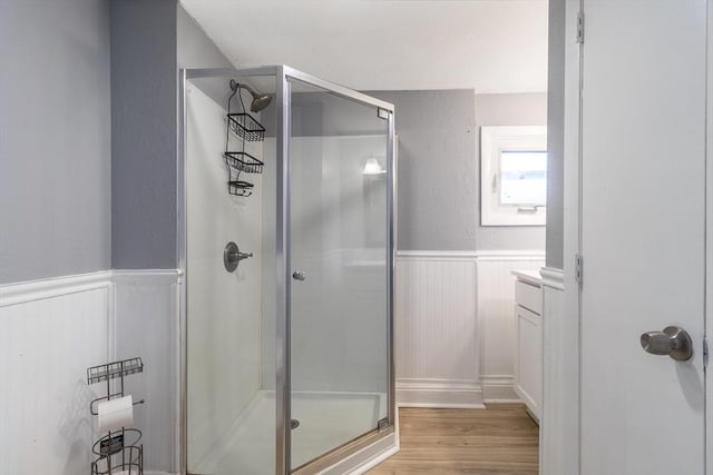 bathroom with hardwood / wood-style flooring and an enclosed shower