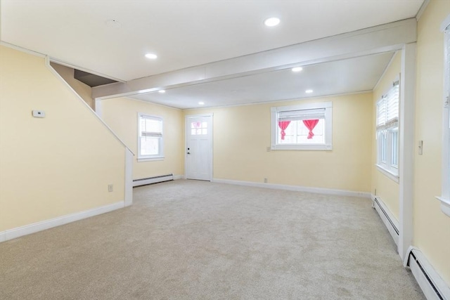 interior space featuring beamed ceiling, light colored carpet, and a baseboard heating unit