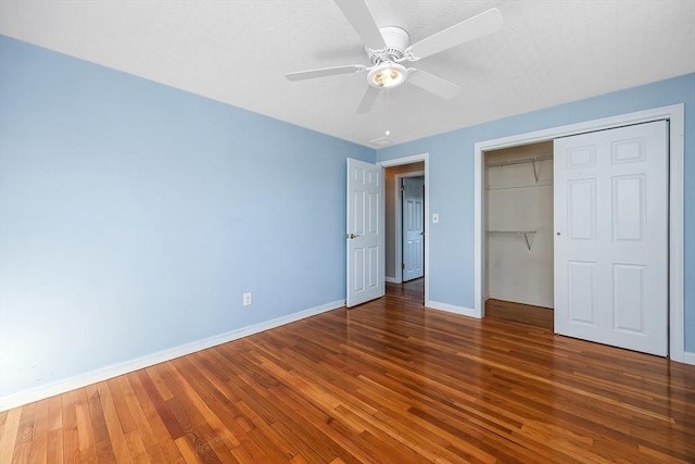 unfurnished bedroom with ceiling fan, dark hardwood / wood-style flooring, and a closet