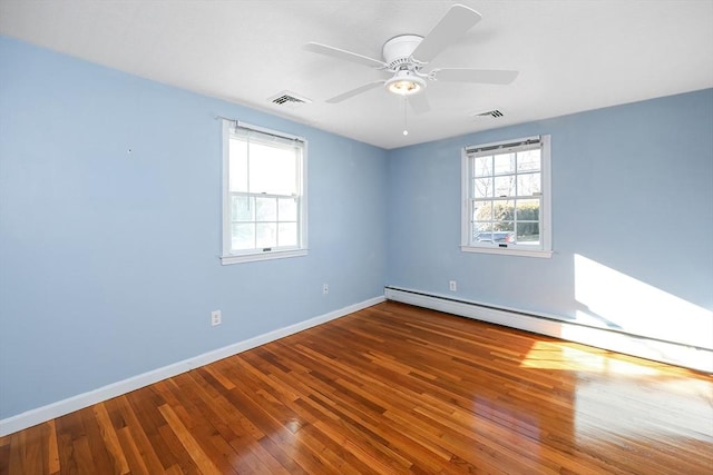 spare room with ceiling fan, hardwood / wood-style floors, a healthy amount of sunlight, and a baseboard radiator