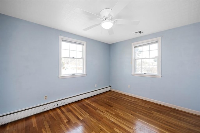 spare room with hardwood / wood-style flooring, ceiling fan, and a baseboard heating unit