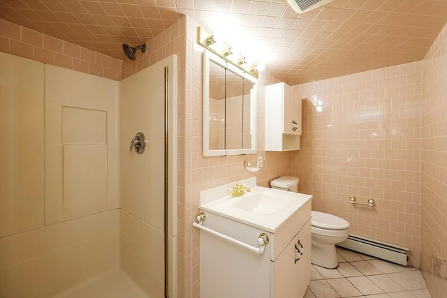 bathroom with a shower, baseboard heating, and tile walls