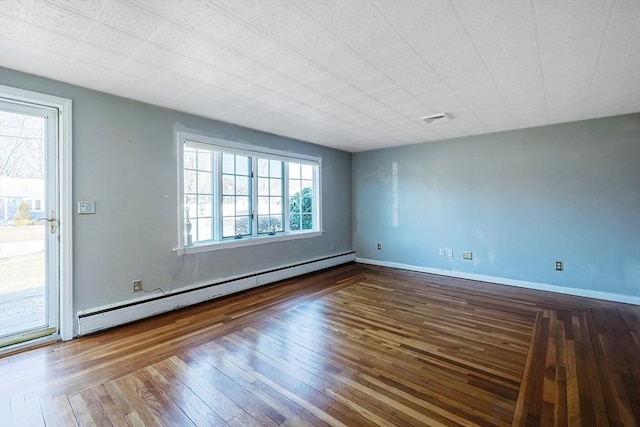 spare room featuring hardwood / wood-style flooring and a baseboard heating unit