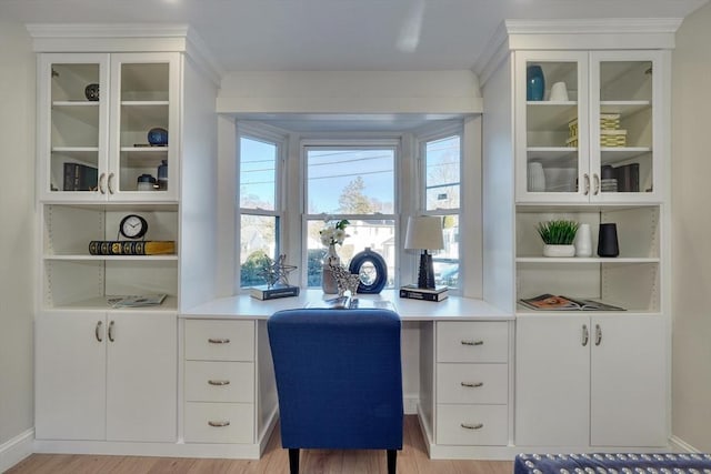 office space featuring built in shelves, built in desk, and light wood-type flooring