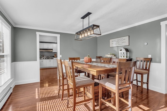 dining room featuring baseboard heating, crown molding, dark hardwood / wood-style flooring, and an inviting chandelier