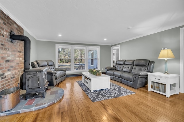 living room featuring light hardwood / wood-style floors, a wood stove, and ornamental molding