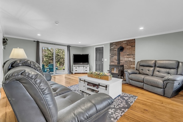 living room with a wood stove, crown molding, and light hardwood / wood-style floors