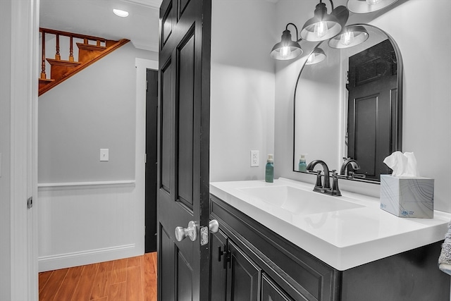 bathroom with hardwood / wood-style floors, vanity, and a chandelier