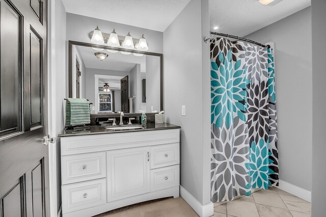 bathroom featuring a textured ceiling, vanity, ceiling fan, tile patterned flooring, and curtained shower