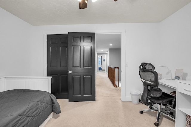 bedroom with ceiling fan, light carpet, and a textured ceiling