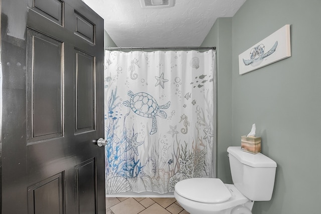 bathroom with a shower with shower curtain, tile patterned floors, a textured ceiling, and toilet