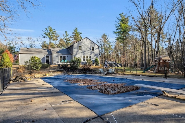 view of pool featuring a playground and a diving board