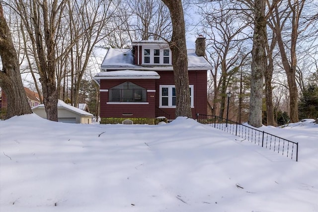 view of front of house featuring a detached garage and a chimney