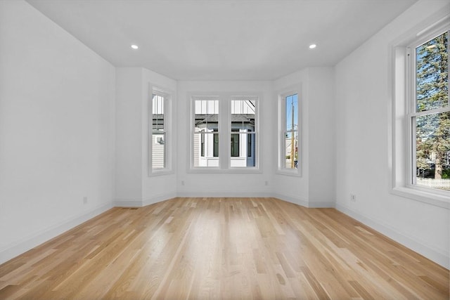 spare room with light wood finished floors, baseboards, and recessed lighting