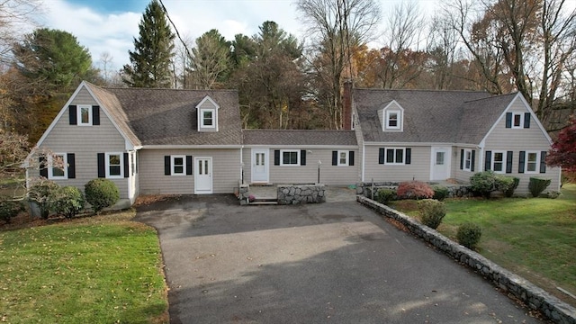 cape cod-style house with a front yard