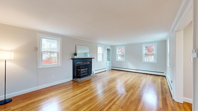 unfurnished living room featuring ornamental molding, light hardwood / wood-style flooring, and a baseboard heating unit