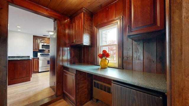 kitchen with radiator, appliances with stainless steel finishes, wooden ceiling, and light hardwood / wood-style flooring