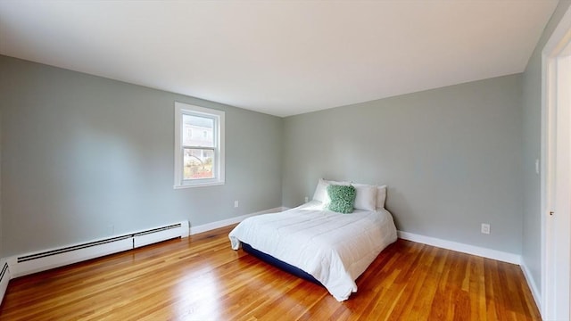 bedroom featuring wood-type flooring and a baseboard radiator