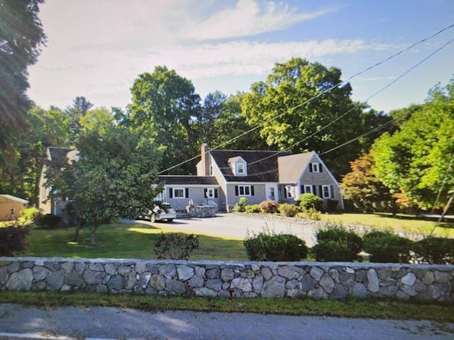 cape cod home featuring a front yard