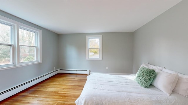 bedroom with light hardwood / wood-style flooring and a baseboard radiator