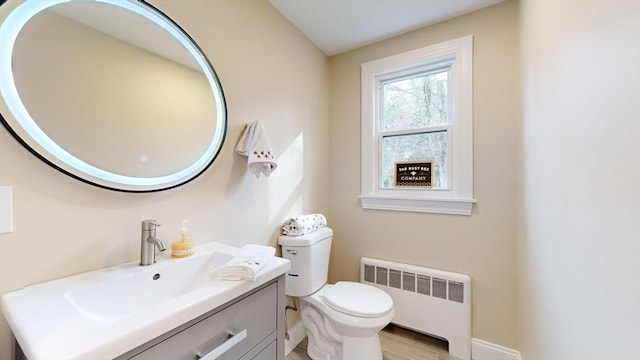 bathroom featuring hardwood / wood-style flooring, vanity, toilet, and radiator heating unit