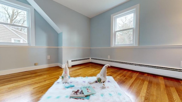 bonus room featuring a baseboard radiator, wood-type flooring, and lofted ceiling