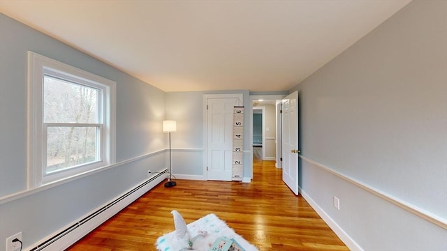 empty room featuring hardwood / wood-style floors and baseboard heating