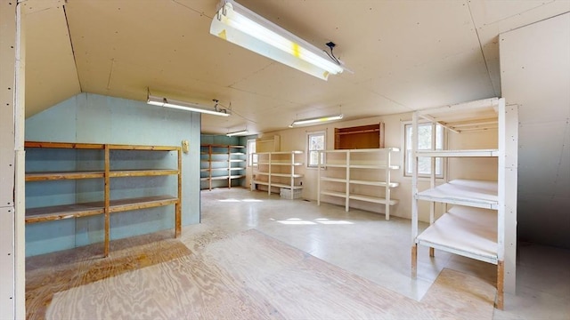 interior space with vaulted ceiling and concrete floors