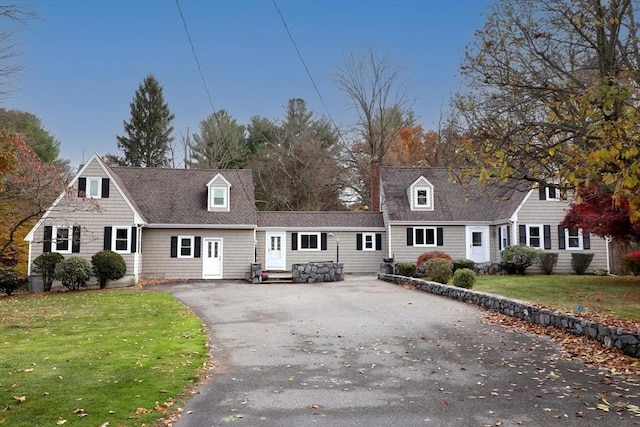 cape cod house with a front yard