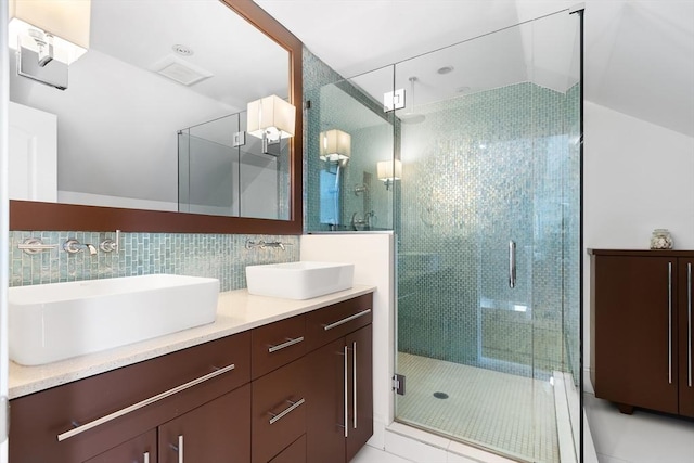 full bathroom featuring a shower stall, double vanity, backsplash, and tile patterned floors