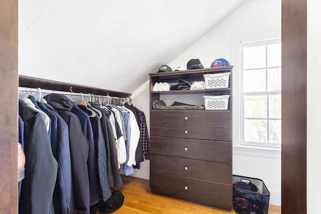 spacious closet with lofted ceiling and wood finished floors