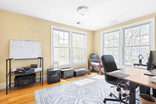 home office with light wood-type flooring and baseboards