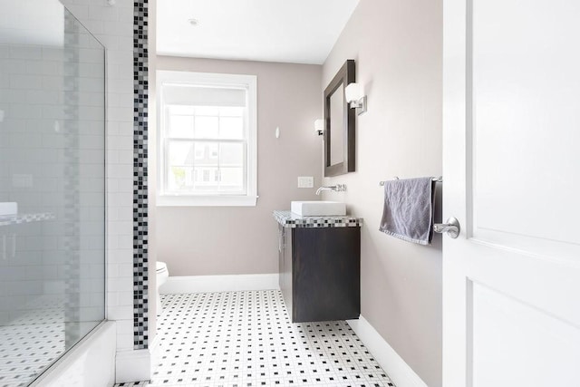 bathroom featuring baseboards, tiled shower, vanity, and tile patterned floors